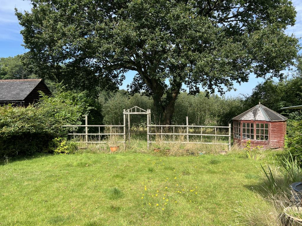 Lot: 65 - THREE-BEDROOM COTTAGE ON PLOT OF 0.34 ACRES FOR IMPROVEMENT - View of garden with summer house